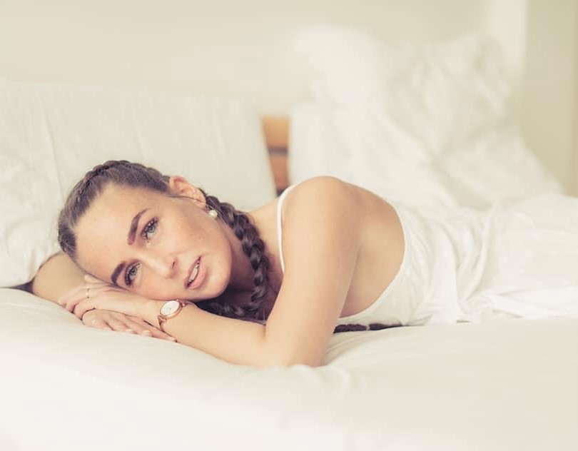 Eine jüngere und ältere Frau sitzen nebeneinander und lächeln in die Kamera